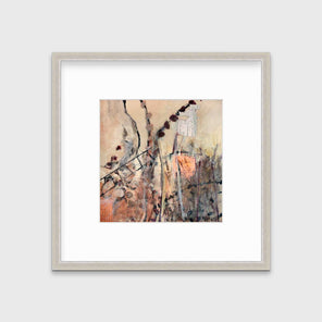 A brown, beige, gold and copper abstract print in a silver frame with a mat hangs on a white wall.