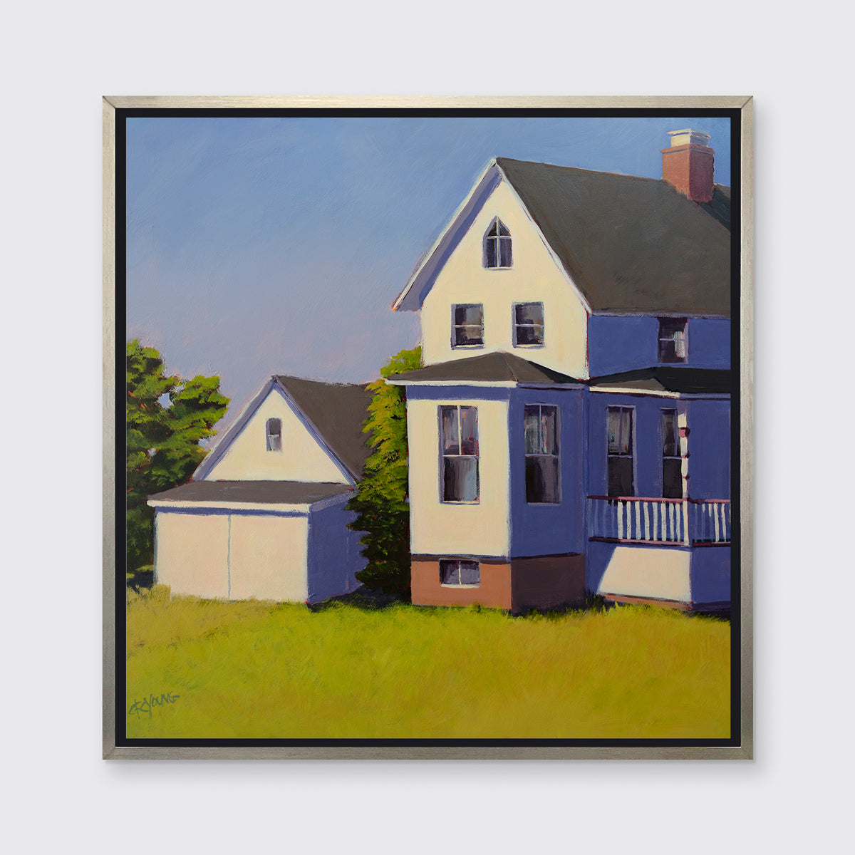 A blue, white and green contemporary house print in a silver floater frame hangs on a white wall.