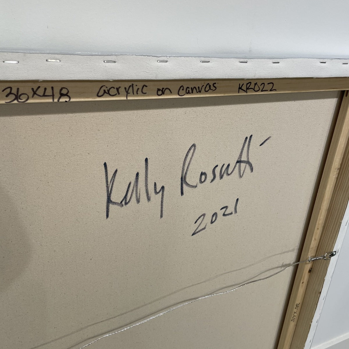 An image of Kelly Rosetti signature on the back of one of her paintngs.