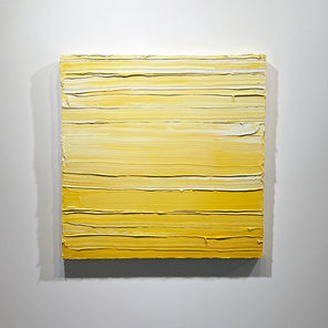 A textured yellow toned painting by Teodora Guererra hangs on a white wall.