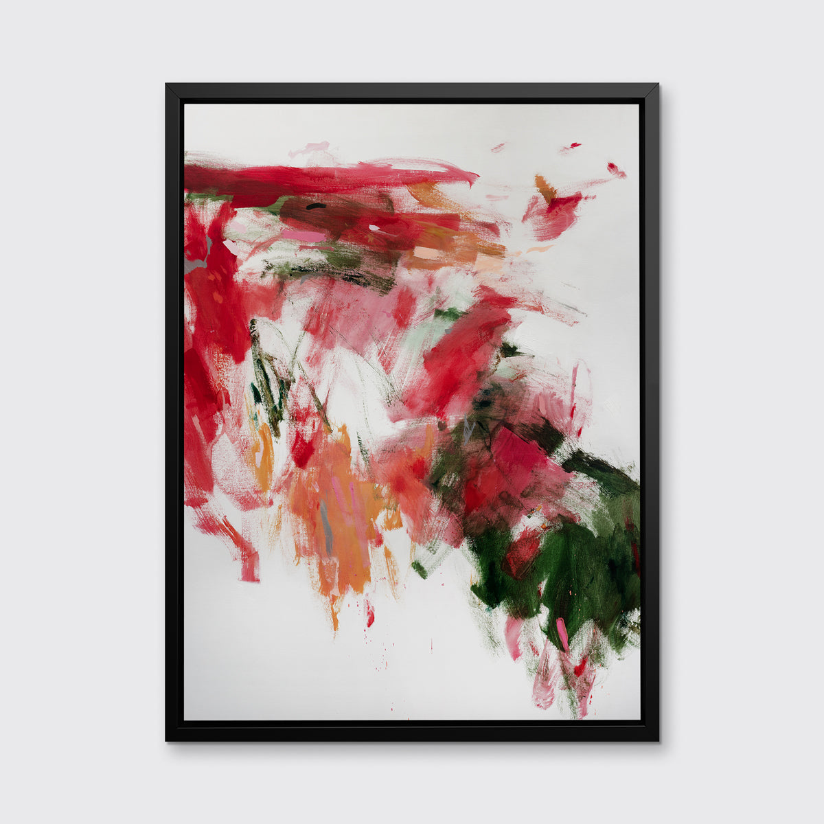 A red, green and white abstract print in a black floater frame hangs on a white wall.