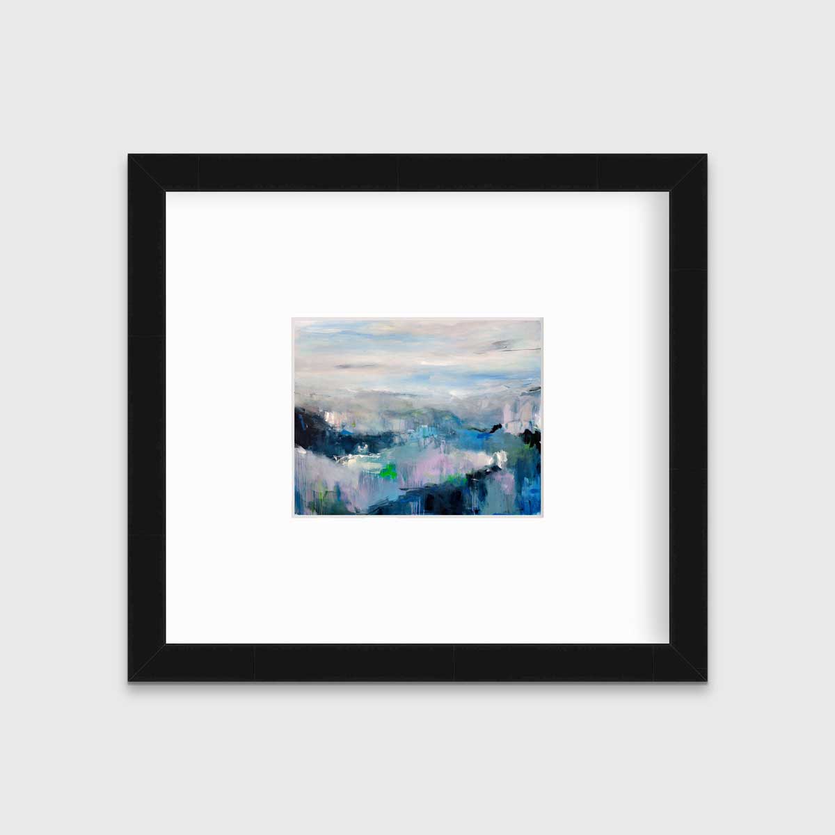 A blue abstract landscape by Kelly Rossetti in a black frame with a mat hangs on a white wall.
