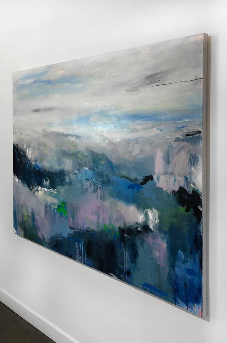 A right side-angle view of an abstract landscape painting by Kelly Rossetti hangs on a white wall.