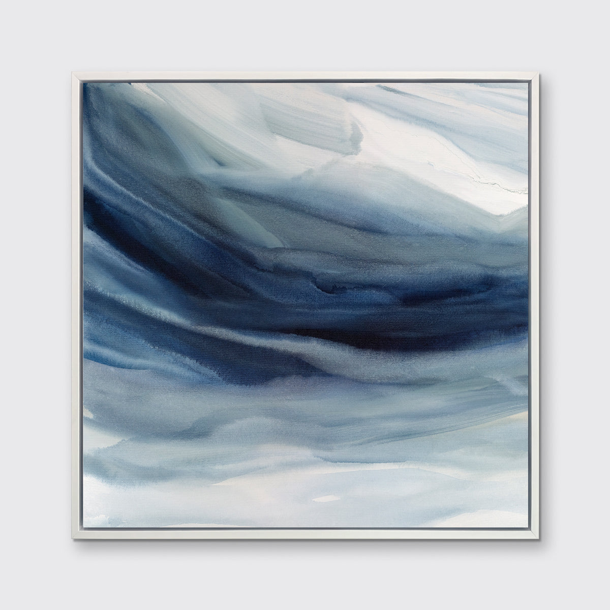 A blue, navy and white abstract print in a white floater frame hangs on a white wall.