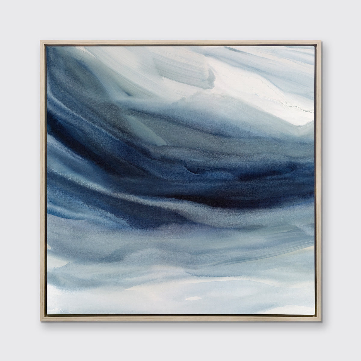 A blue, navy and white abstract print in a white oak wood floater frame hangs on a white wall.