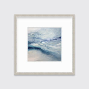 A blue, white, teal and light purple abstract print in a silver frame with a mat hangs on a white wall.