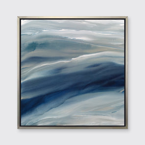 A blue, teal, beige and white abstract print in a silver floater frame hangs on a white wall.