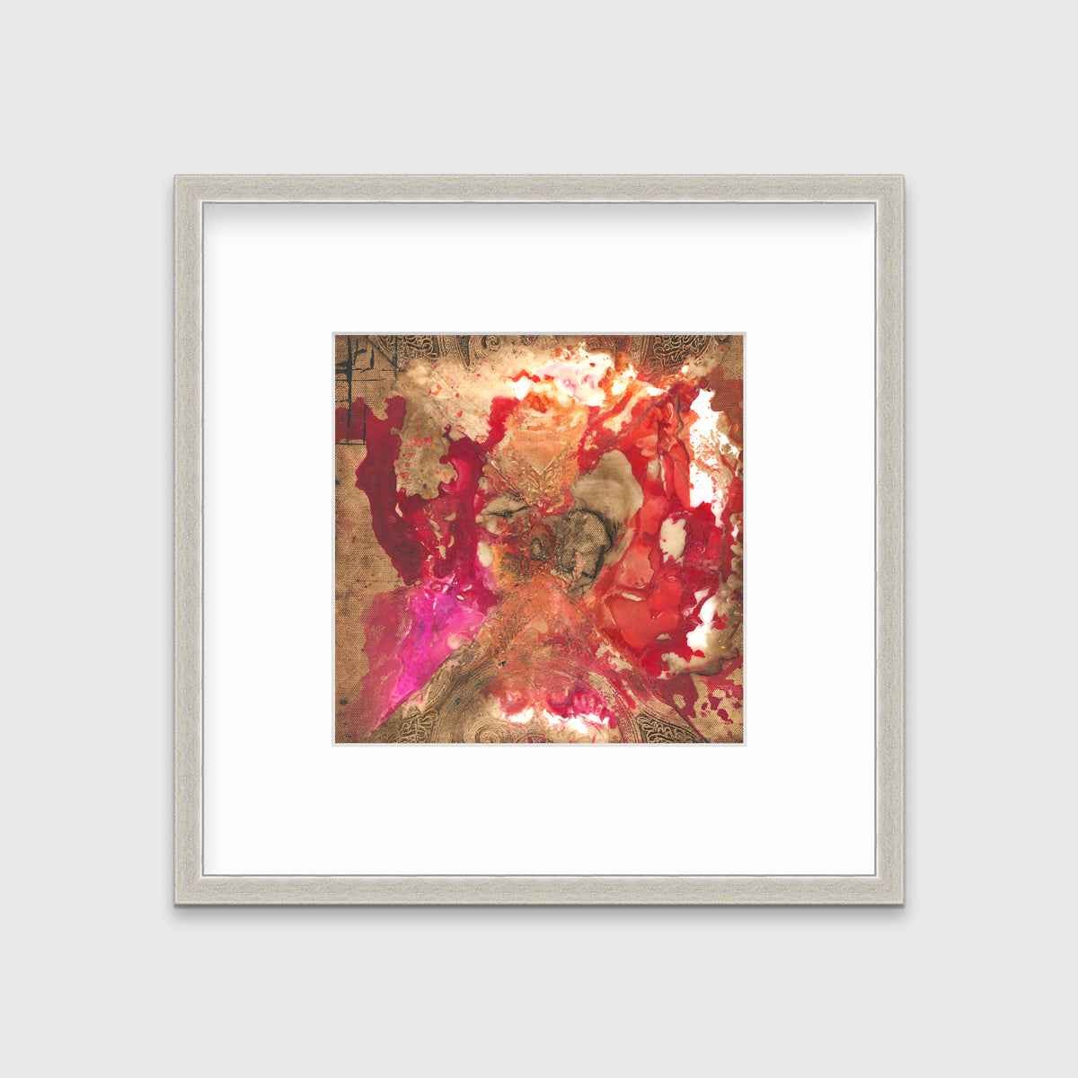 A gold, red and pink abstract print in a silver frame with a mat hangs on a white wall.