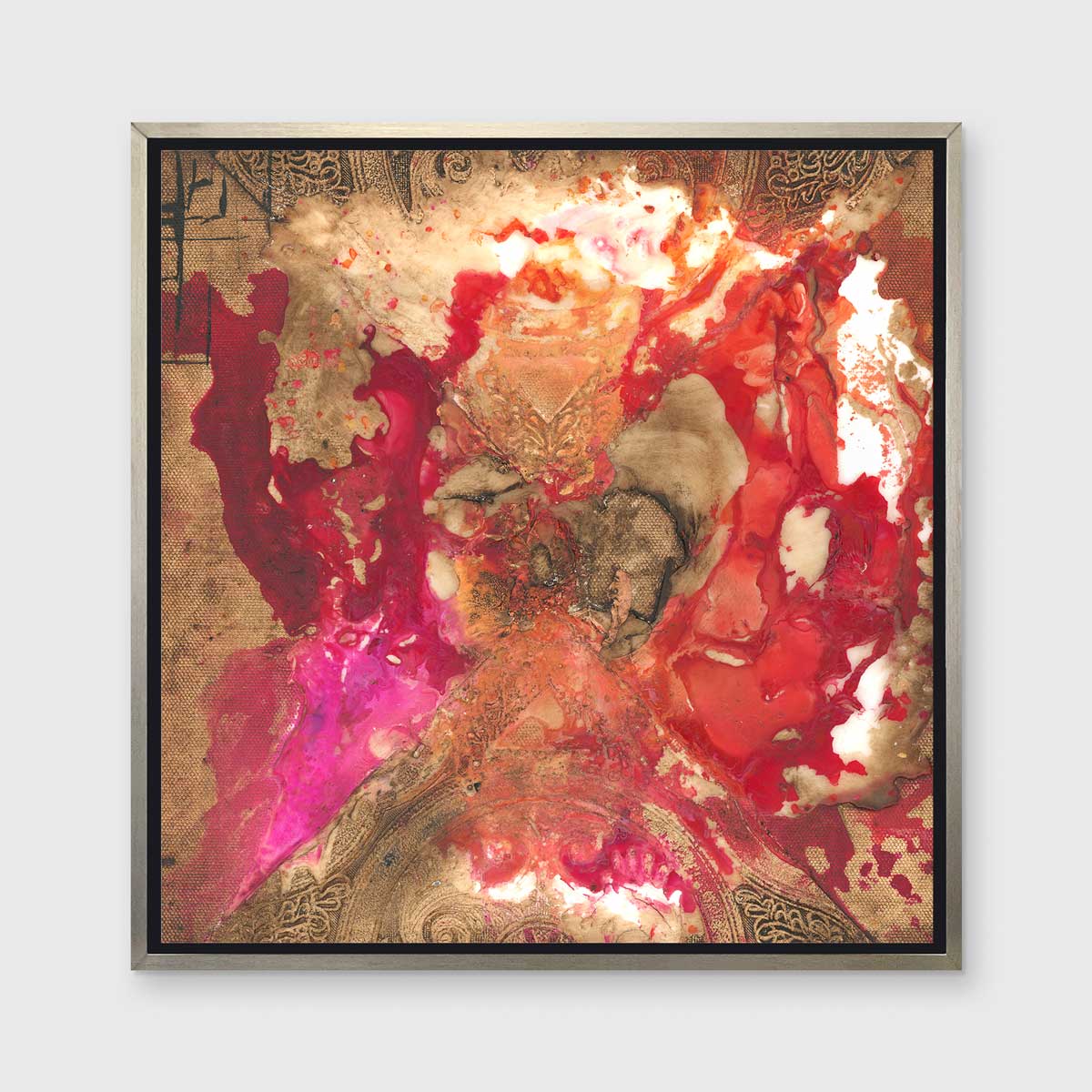 A gold, red and pink abstract print in a silver floater frame hangs on a white wall.