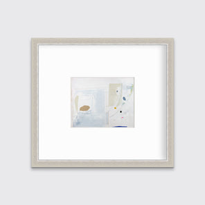 A white, blue, beige and light green abstract print in a silver frame with a mat hangs on a white wall.