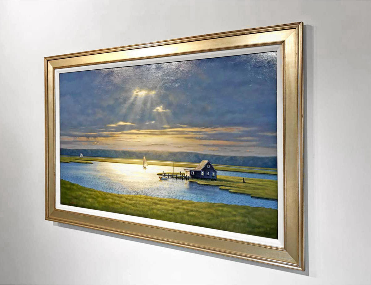 A right angled-side image of "Into the Light" in a gold frame and on a white wall.