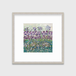 A purple, blue and green abstract floral print in a silver frame with a mat hangs on a white wall.