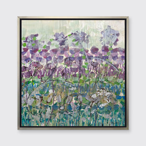 A purple, green and blue abstract floral print in a silver floater frame hangs on a white wall.