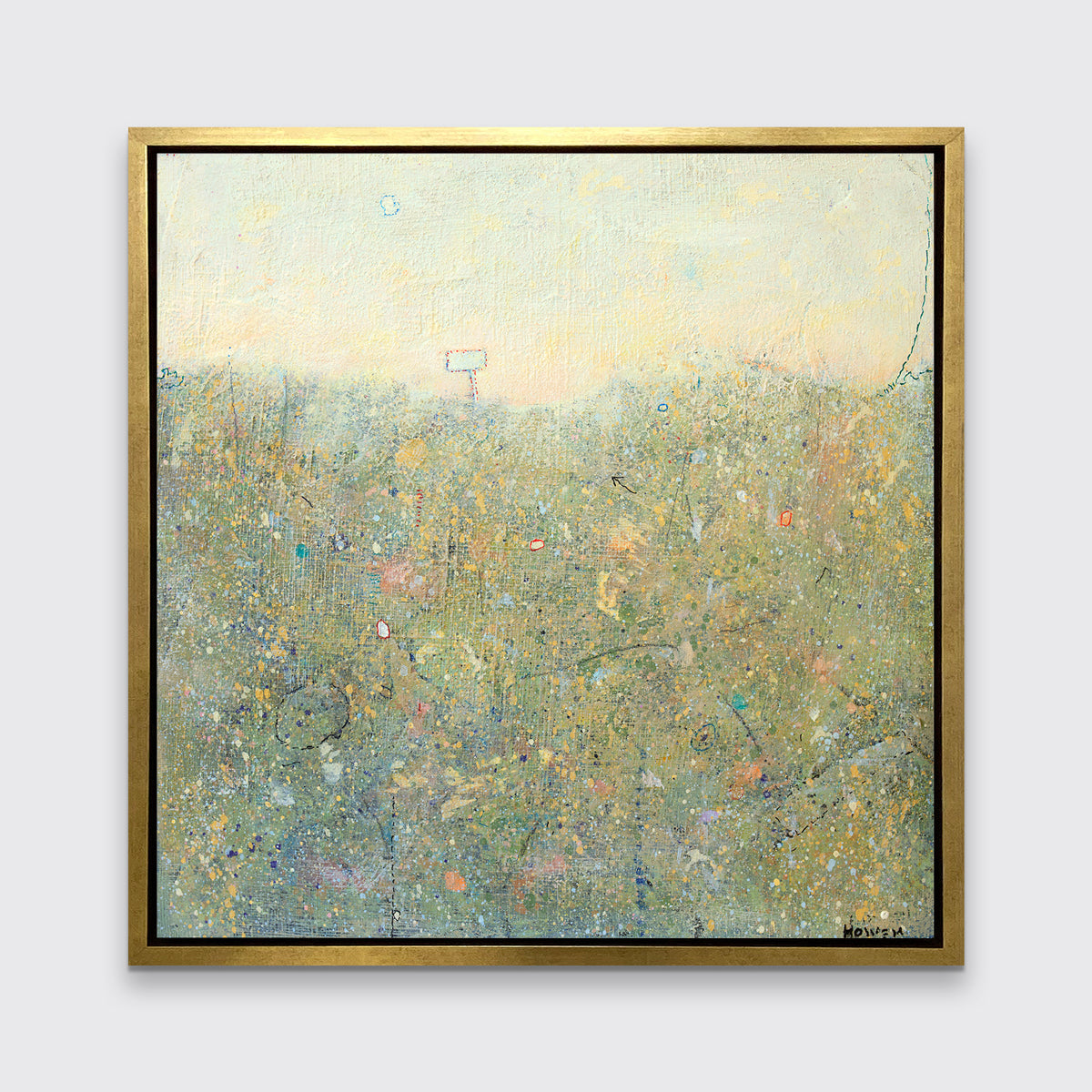 A green and light yellow abstract landscape print in a gold floater frame hangs on a white wall.