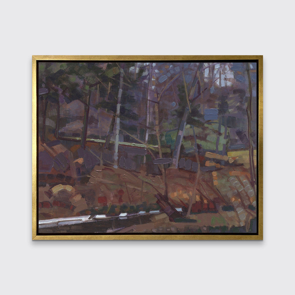 A brown, grey and green abstract landscape print in a gold floater frame hangs on a white wall.