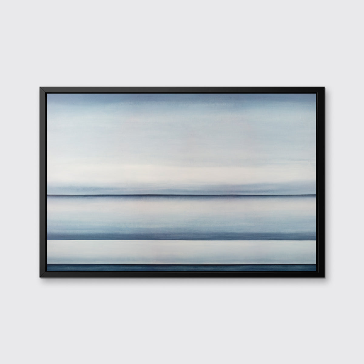 A tonal blue abstract landscape print in a black floater frame hangs on a white wall.