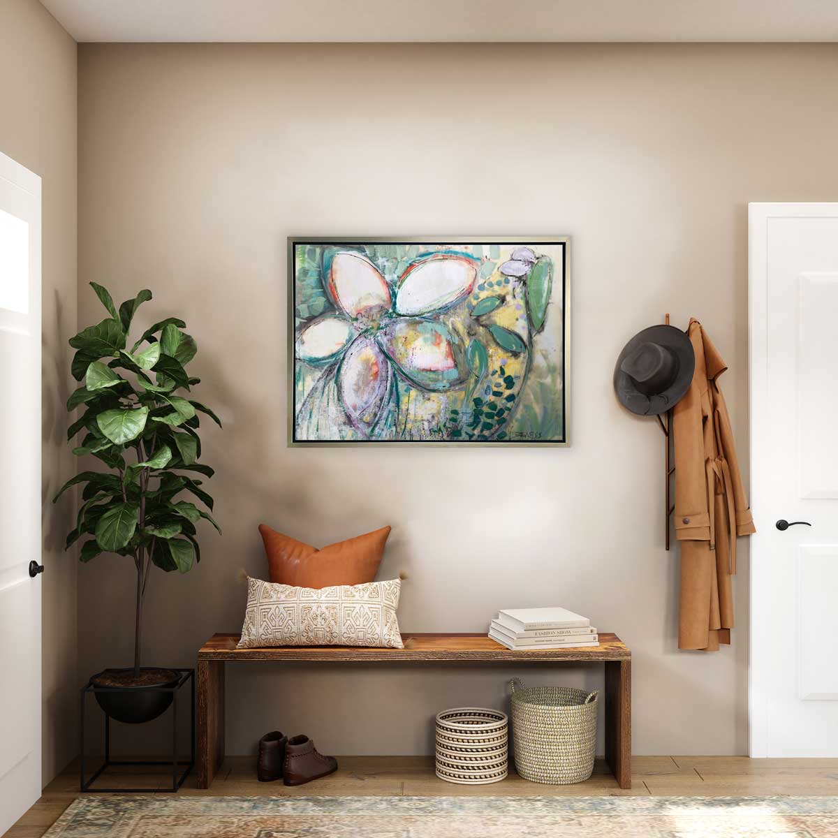 An abstract floral print in a silver floater frame hangs on beige wall over a wooden bench and a potted plant. In a homes entry way. .