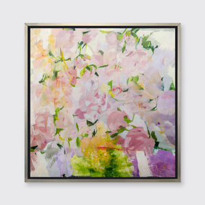 A multicolored floral abstract print in a silver floater frame hangs on a white wall.