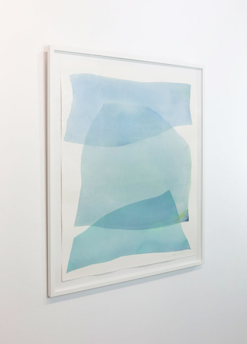 A watercolor painting of blue and turquoise stacked forms painted by Nealy Hauschildt is seen at an angle on a gallery wall.