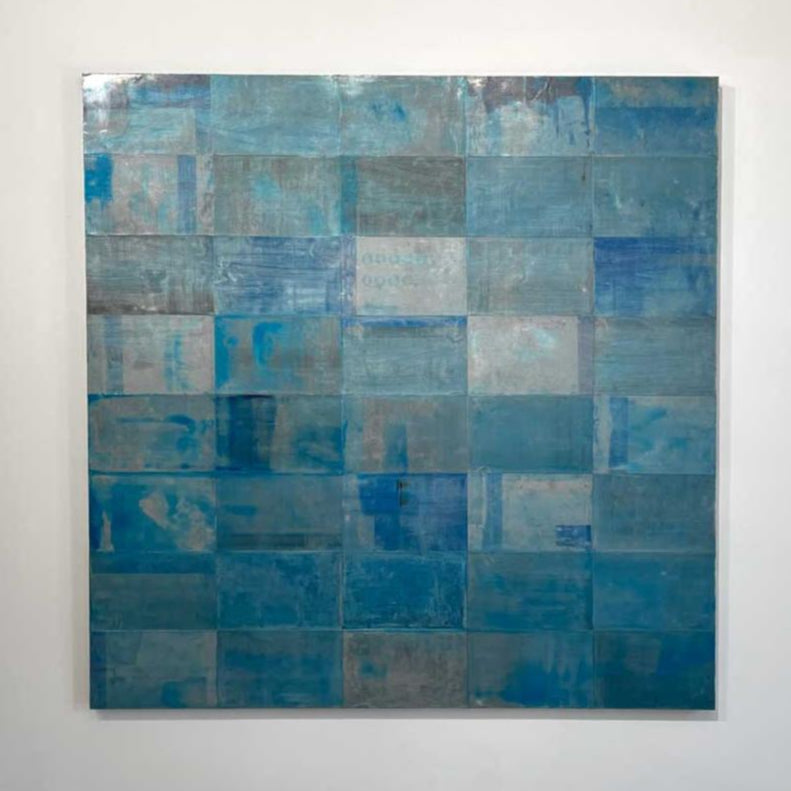 An abstract painting with a grid appearance and a blue wash by Ned Martin hangs on a white wall with a view from straight on. 