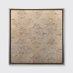 A light gold and silver abstract print in a silver floater frame hangs on a white wall.
