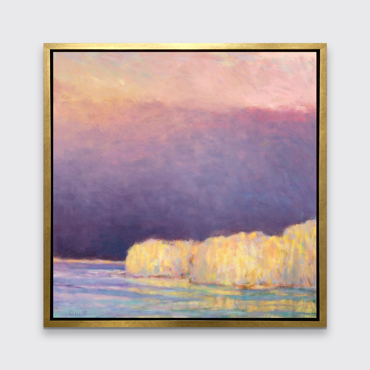 A violet, pink, yellow and light blue abstract landscape print in a gold floater frame hangs on a white wall.