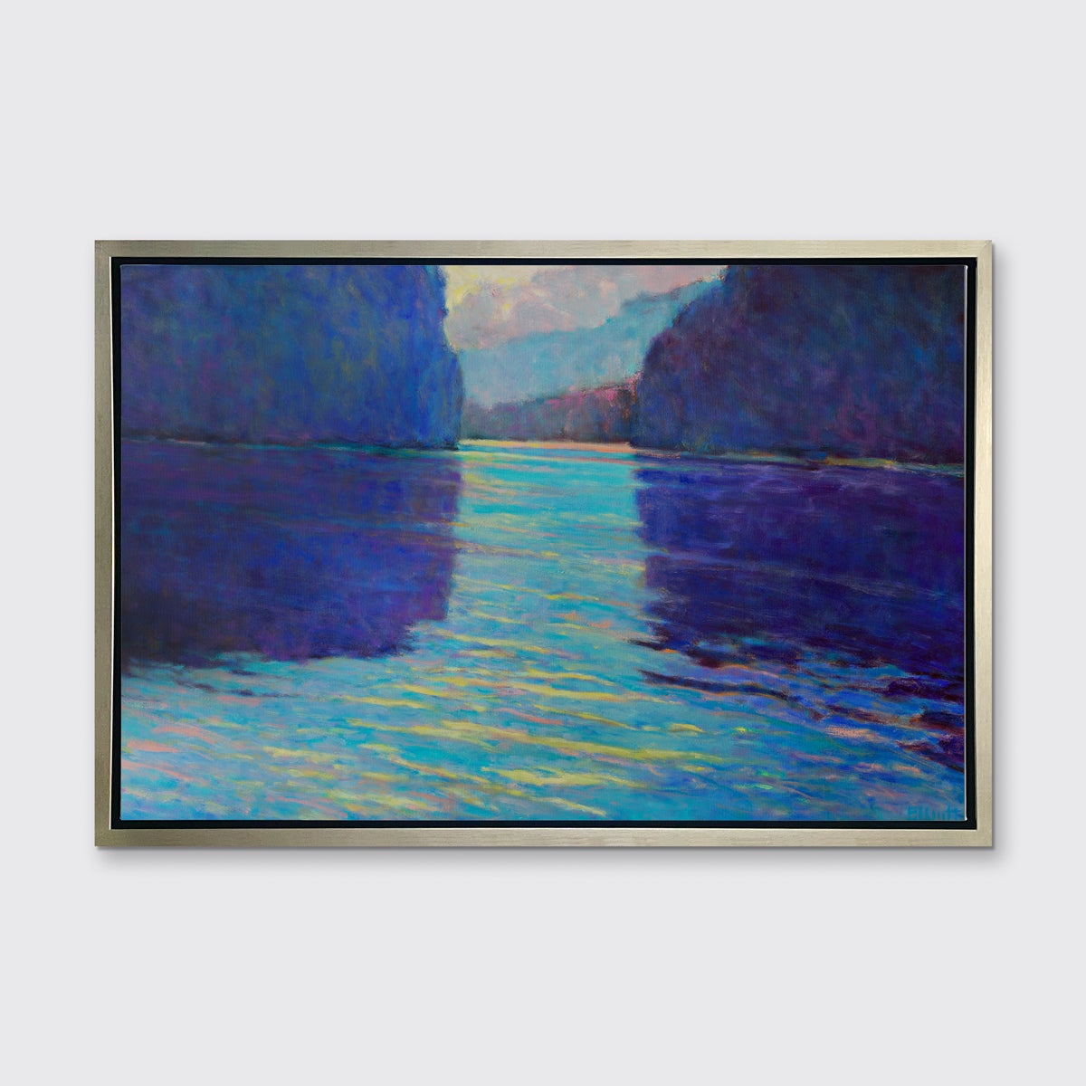 A dark blue and teal abstract landscape print in a silver floater frame hangs on a white wall.