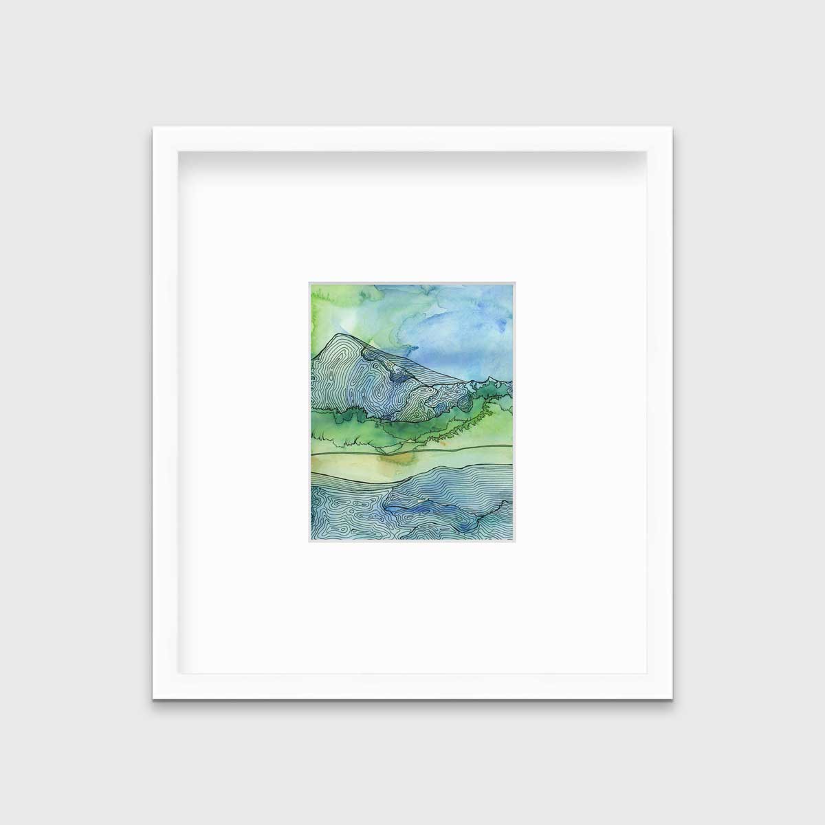 A blue and green landscape illustration print framed in a white frame with a mat hangs on a light grey wall.