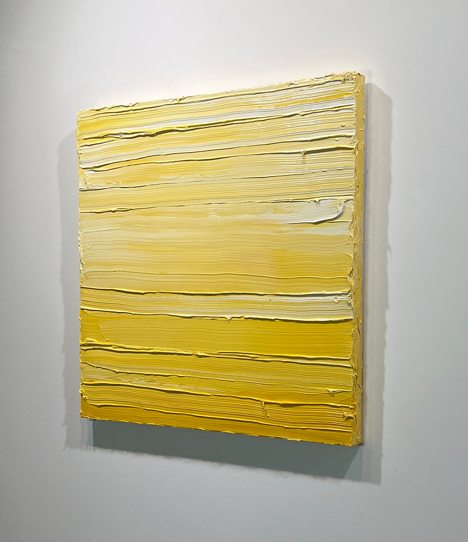 A right side-view of a textured yellow toned painting by Teodora Guererra hangs on a white wall.