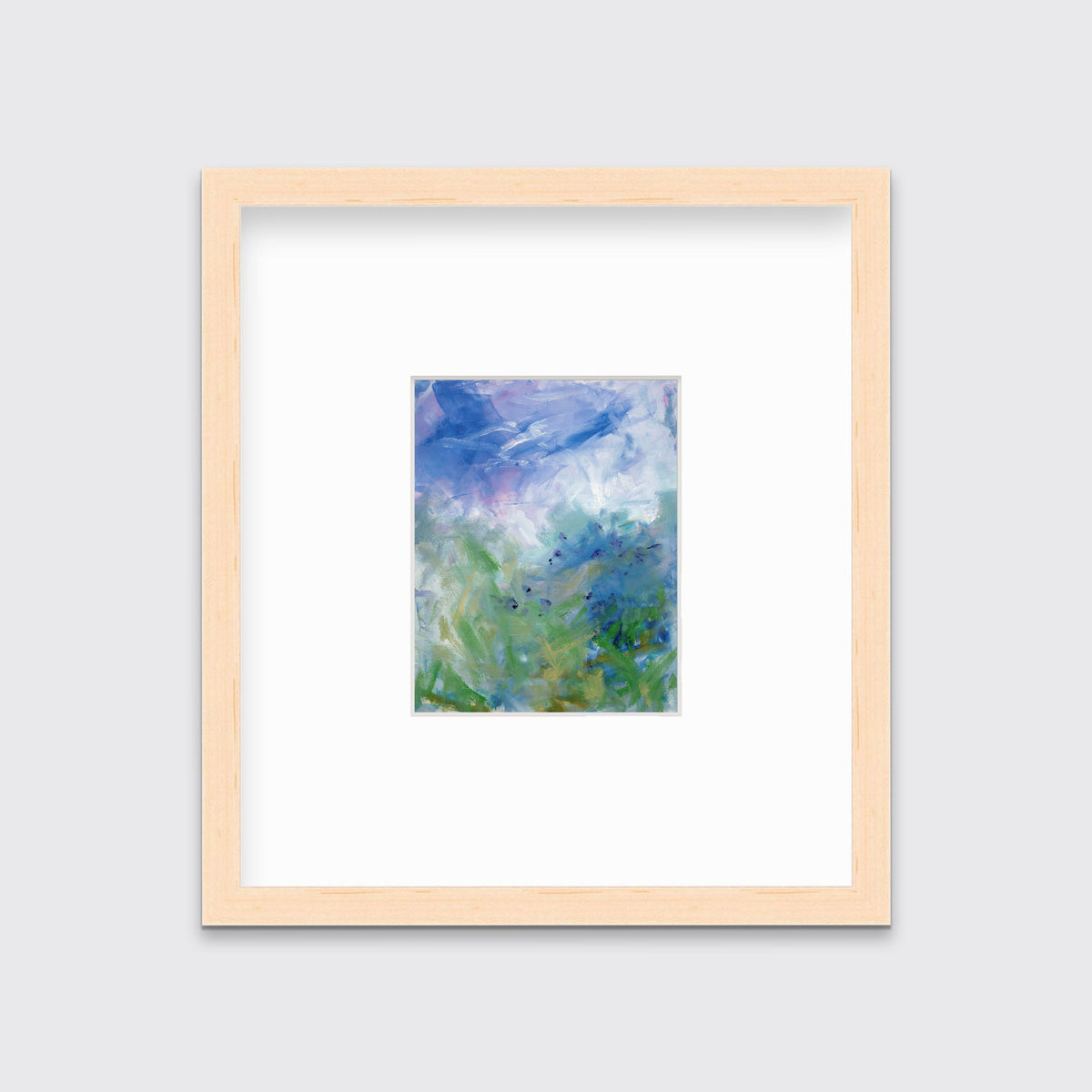 A blue, purple and green abstract print in a natural wood frame with a mat hangs on a white wall.