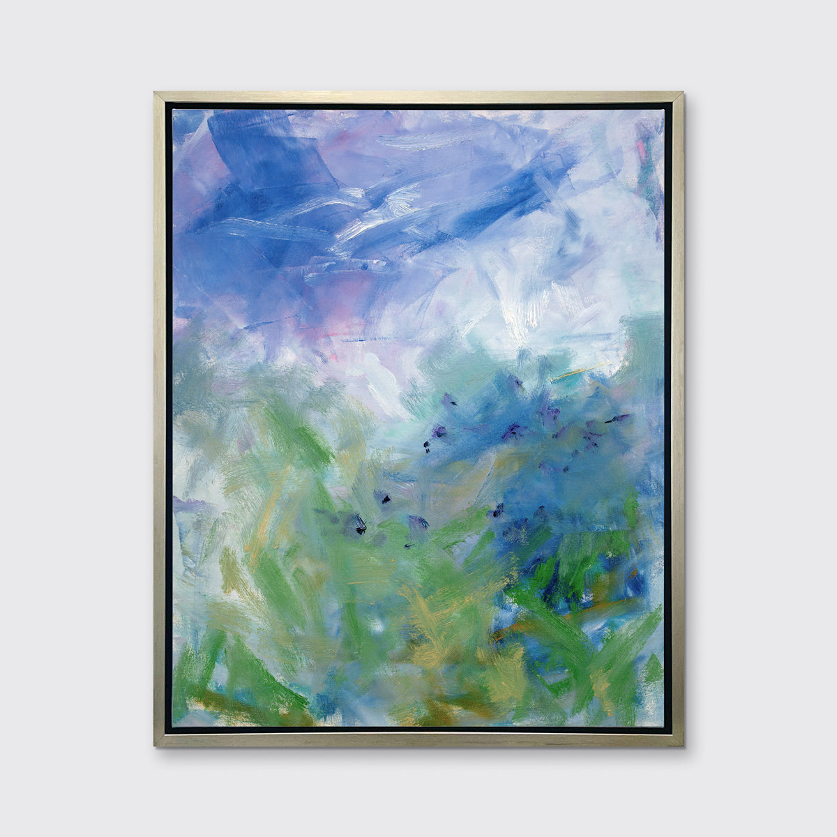 A blue, purple and green abstract print in a silver floater frame hangs on a white wall.