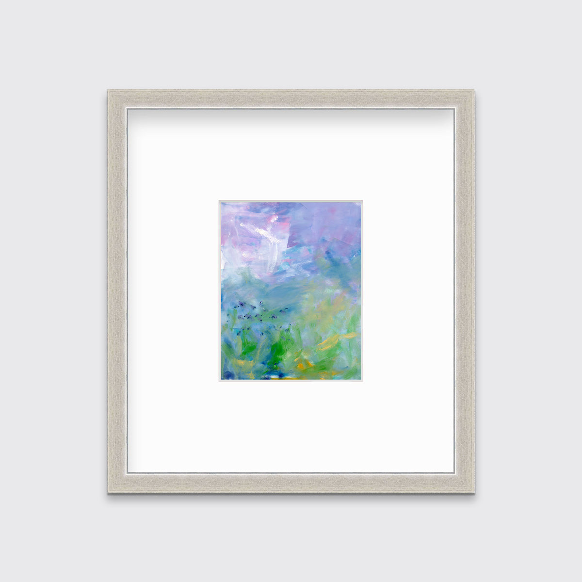 A blue, purple and green abstract print in a silver frame with a mat hangs on a white wall.