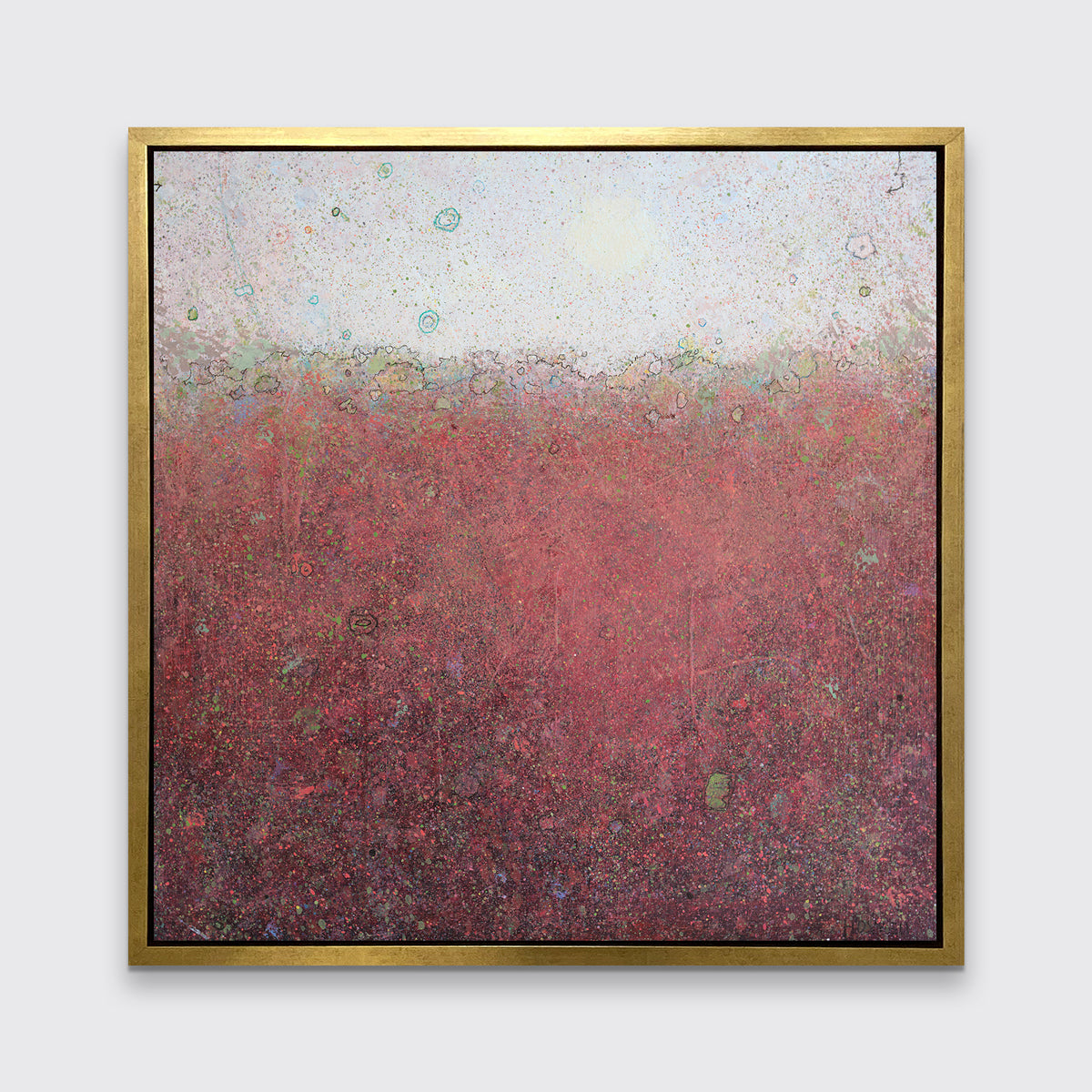 A red abstract landscape print in a gold floater frame hangs on a white wall.
