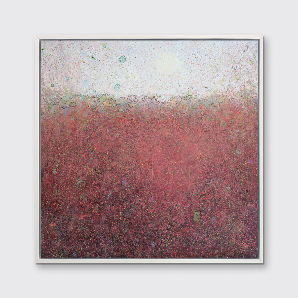 A red abstract landscape print in a white floater frame hangs on a white wall.