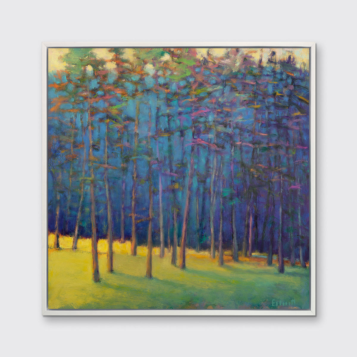A blue, green and yellow abstract tree landscape print in a white floater frame hangs on a white wall.