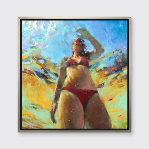 An abstract figurative print of a woman underwater in a red bikini, hangs in a warm silver floater frame on a white wall.