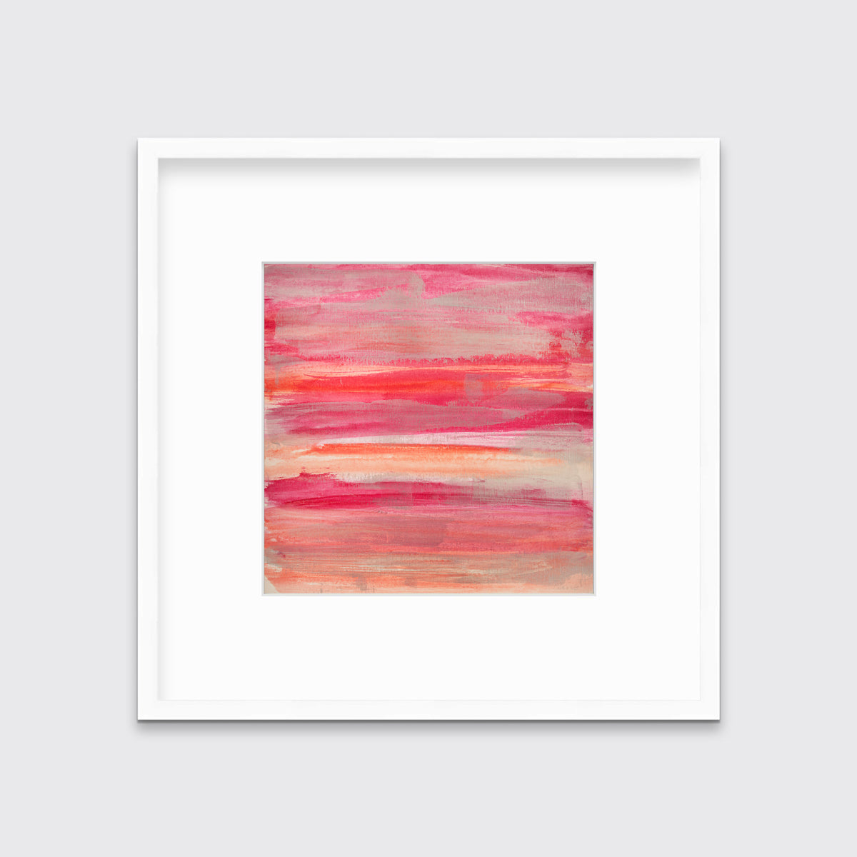 A pink, silver and orange abstract print in a white frame with a mat hangs on a white wall.