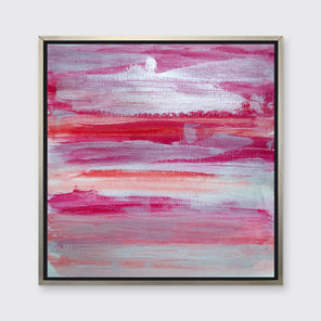 A pink, white, silver and red abstract print in a silver floater frame hangs on a white wall.