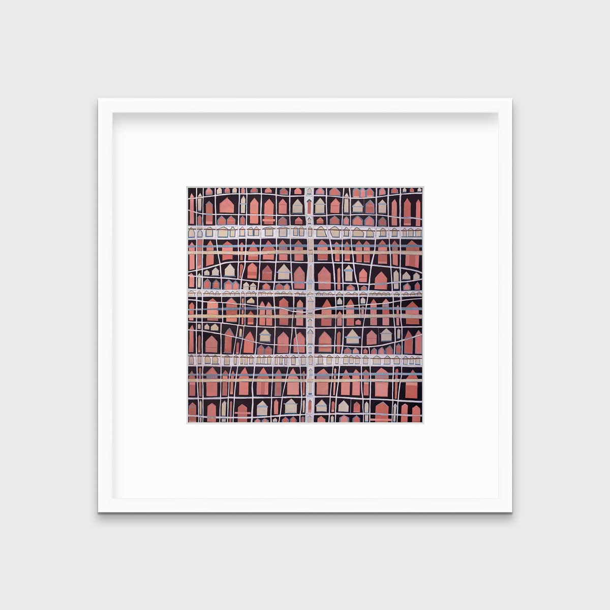 A pink, white and black abstract house print in a white frame with a mat hangs on a white wall.