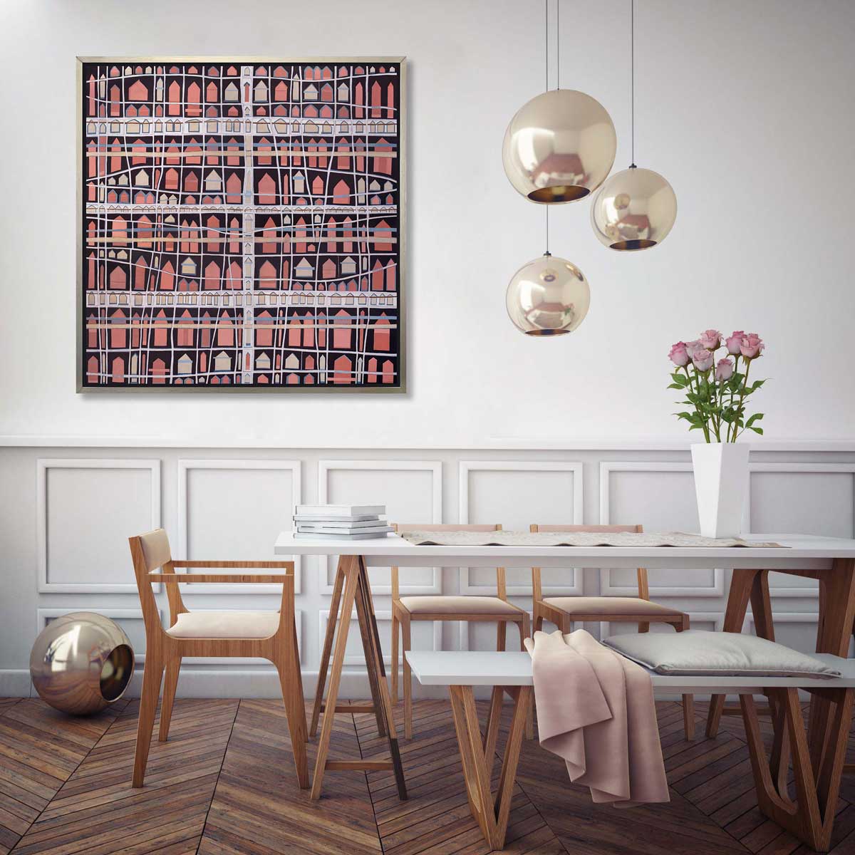 A pink, white and black abstract house print in a silver floater frame hangs on a white wall above a white table with a stack of books, three wood chairs and a white bench.