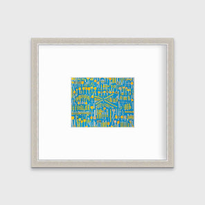A blue and yellow abstract print in a silver frame with a mat hangs on a white wall.