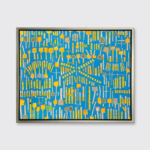 A blue and yellow abstract print in a silver floater frame hangs on a white wall.