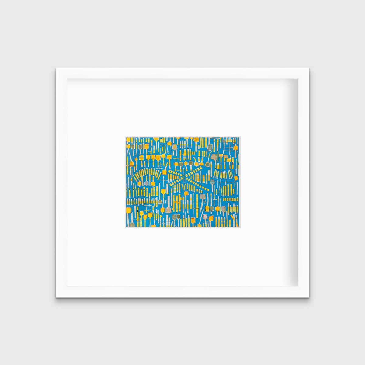 A blue and yellow abstract print in a white frame with a mat hangs on a white wall.