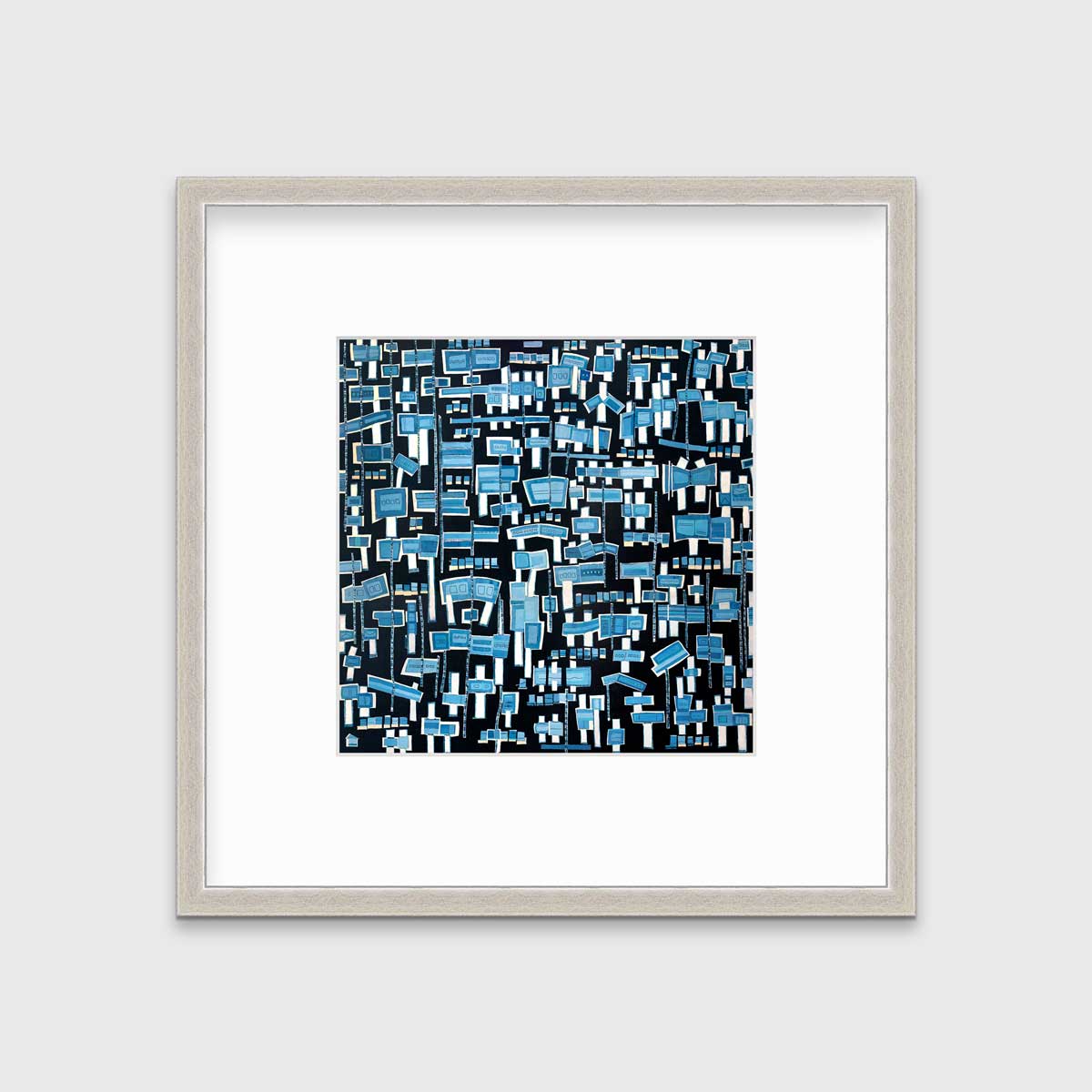 A blue, white and black abstract print in a silver frame with a mat hangs on a white wall.