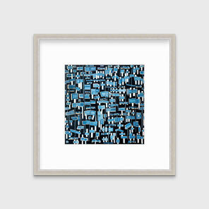 A blue, white and black abstract print in a silver frame with a mat hangs on a white wall.