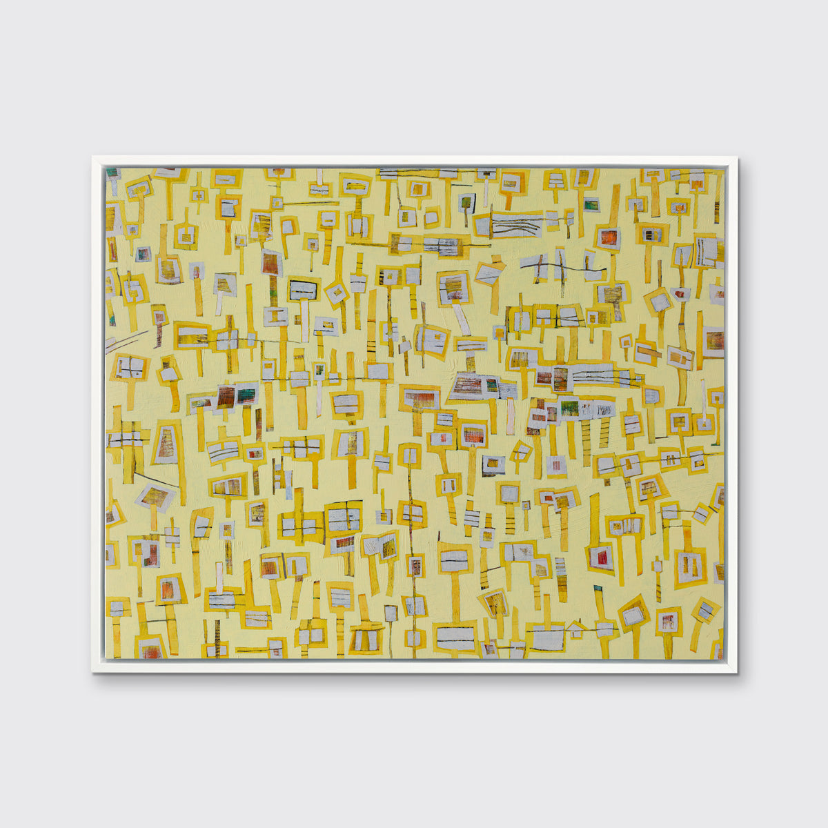 A yellow and grey abstract print in a white floater frame hangs on a white wall.