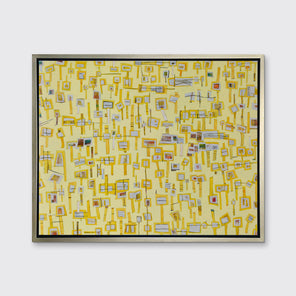 A yellow and grey abstract print in a silver floater frame hangs on a white wall.