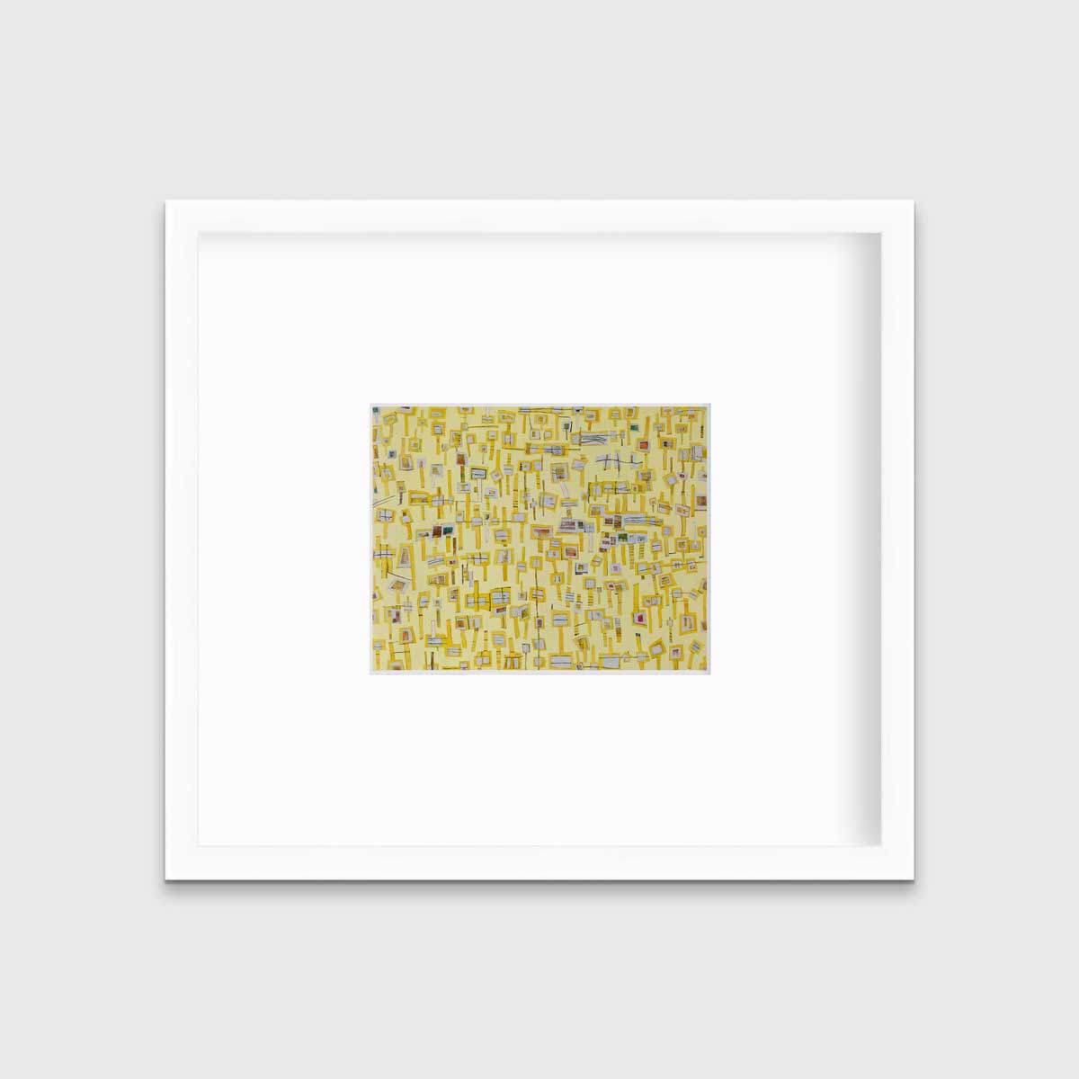 A yellow and grey abstract print in a white frame with a mat hangs on a white wall.