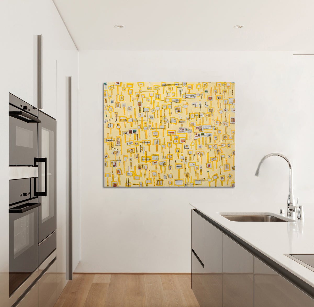 An abstract painting of yellow "lollipops" on a yellow background is hung in a kitchen area.