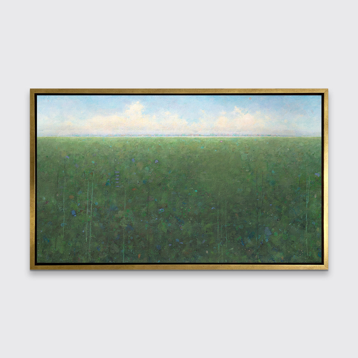 A green, light blue and white abstract landscape print in a gold floater frame hangs on a white wall.
